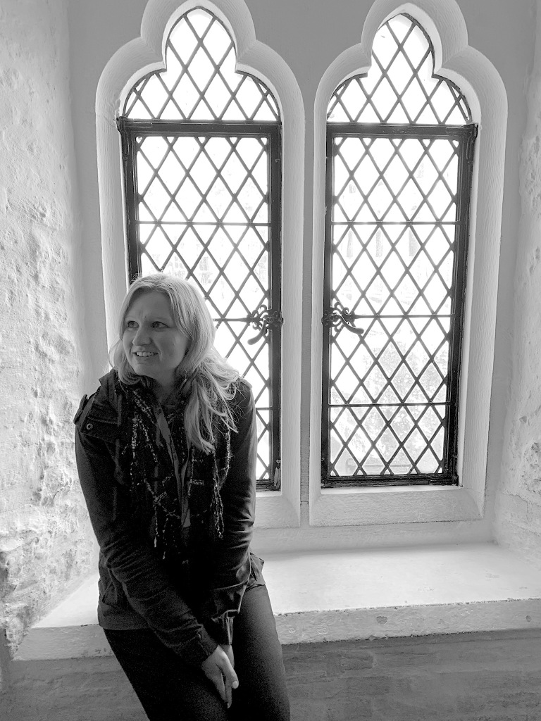 Ashley sitting in front of a paned window in the Tower of London